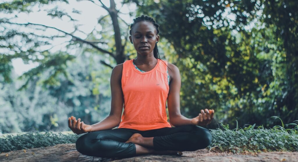 This image depicts a woman relieving stress by performing a meditative yoga pose.
